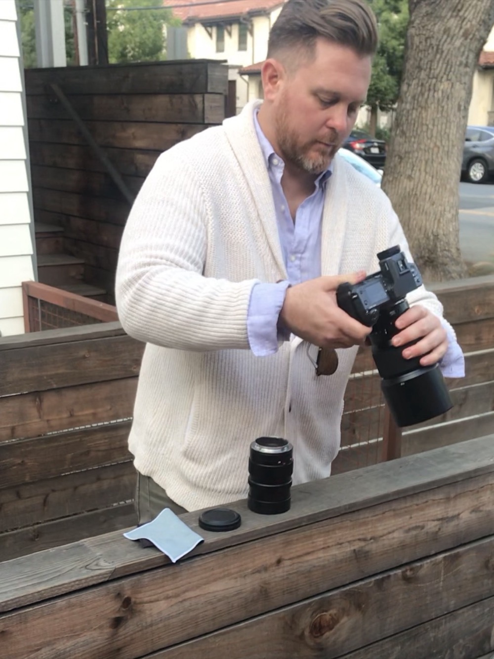 Paul Von Rieter swapping lenses at a wooden bench